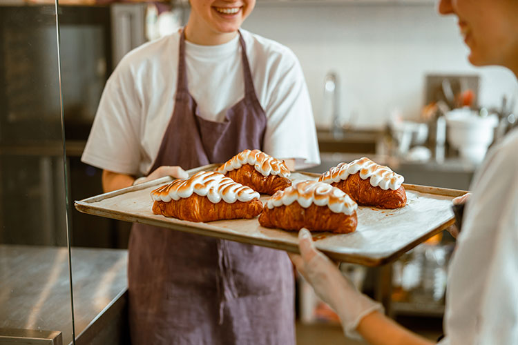 positive-women-hold-delicious-decorated-croissants